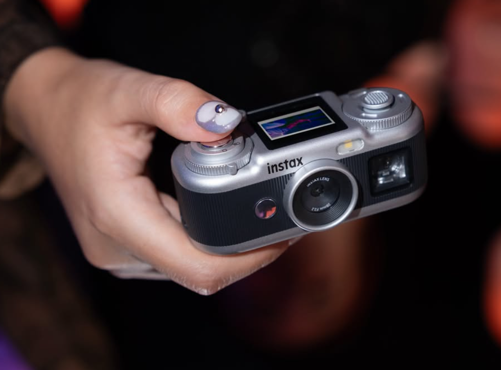 한 손에 잡히는 instax Pal 2와 상단 화면의 제품 사진