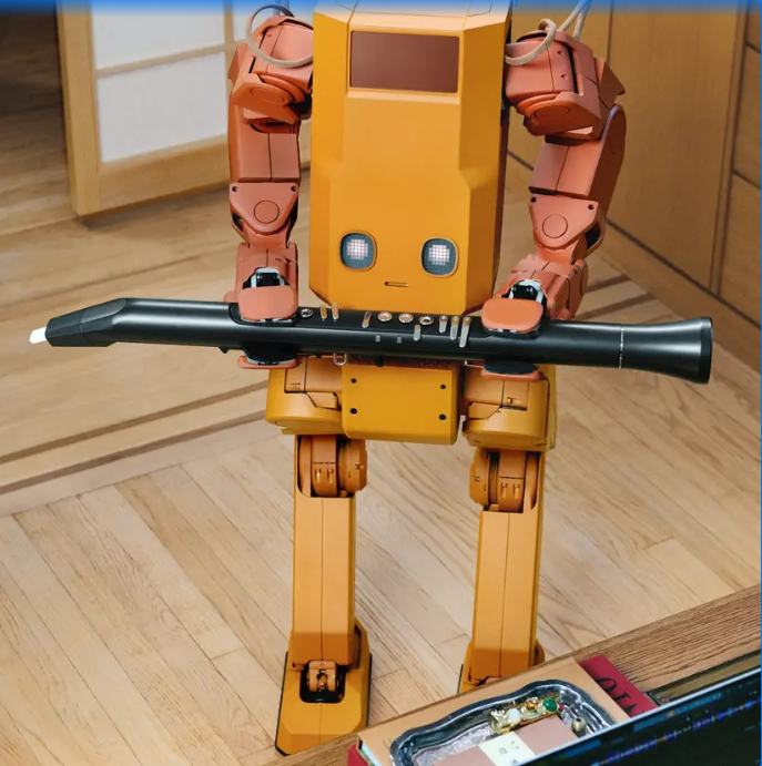 작업대 앞에서 긴 물체를 양손으로 잡고 있는 Voxel 로봇