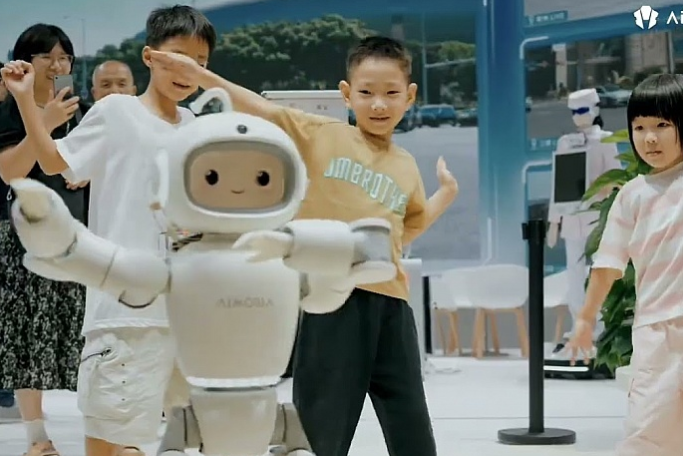 어린이들 앞에서 양팔을 펼친 AiMOGA Mobo 로봇